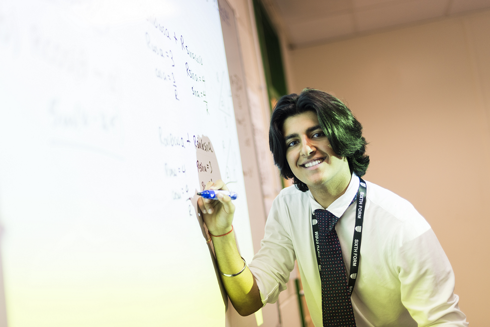 Student writing notes on a white board